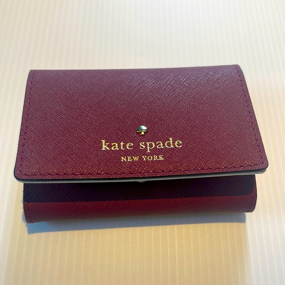 Kate Spade small wallet. Lovely maroon color. It’s new with tags.